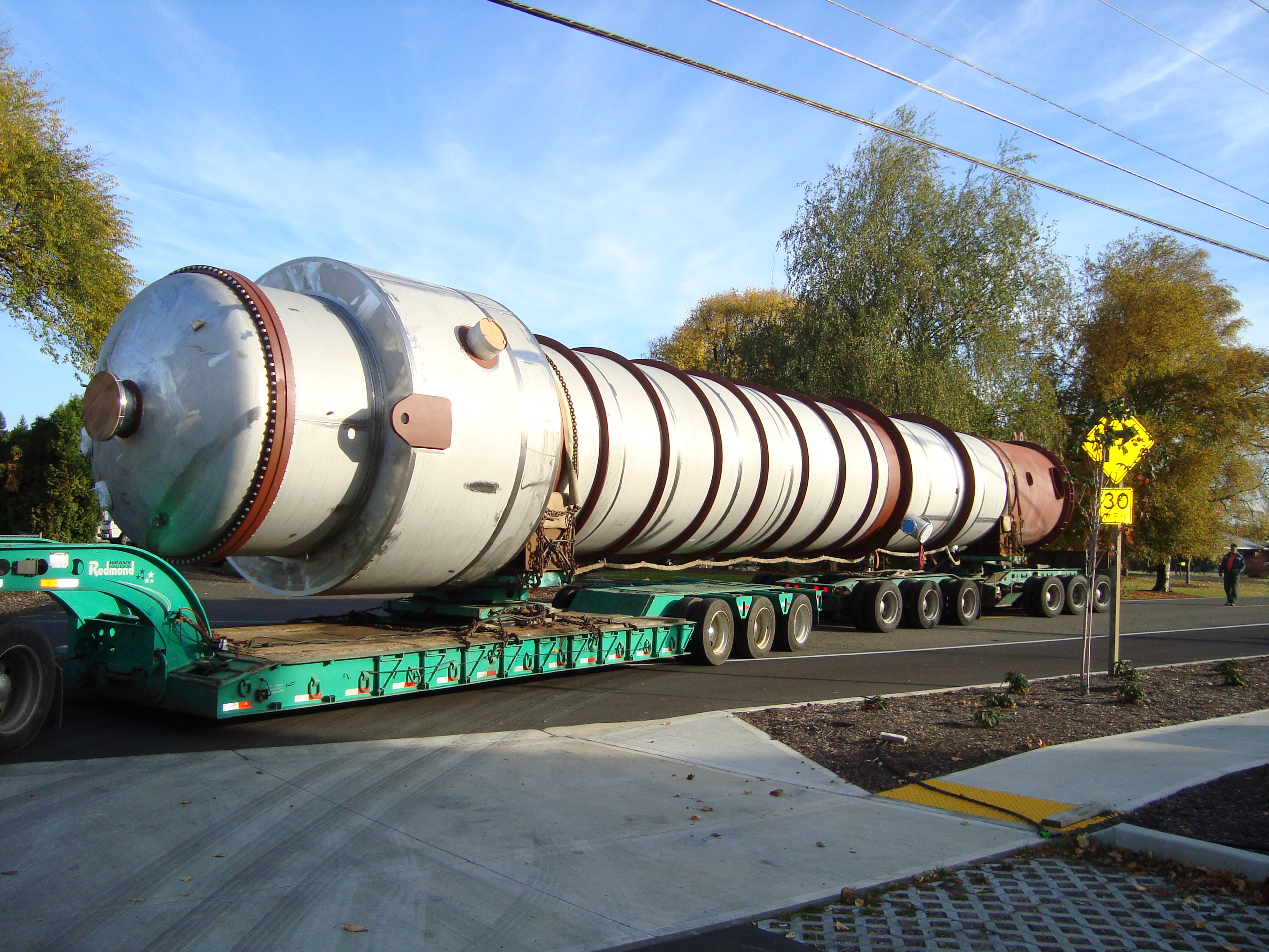 A large fabricated pressure vessel on a heavy-haul trailer during over-the-road transport